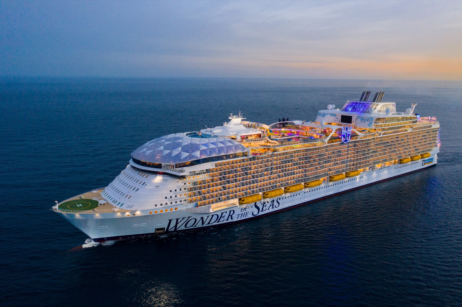 Royal Caribbean Wonder of the Seas sailing on the ocean at dusk